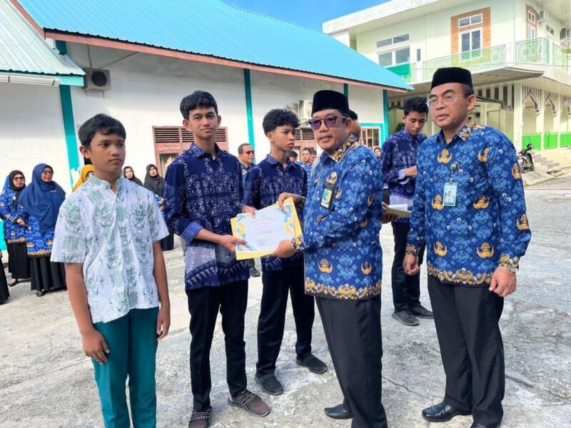 Kepala Kemenag Aceh Barat, H. Abrar ZYM, menyerahkan penghargaan kepada siswa madrasah peraih juara Olimpiade Sains Madrasah Aceh (OSMA) 2025 di Meulaboh.