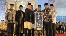 Wakil Gubernur Aceh Fadhlullah menyerahkan piala juara umum MTQ Aceh ke-37 kepada Bupati Aceh Besar, Syech Muharram, pada malam penutupan di Pidie Jaya, Jumat (7/11/2025).