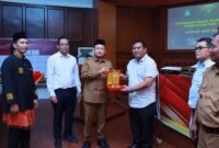 Bupati Aceh Jaya menyerahkan penghargaan kepada SKPK terinovatif pada acara penganugerahan PENA JAYA 2025