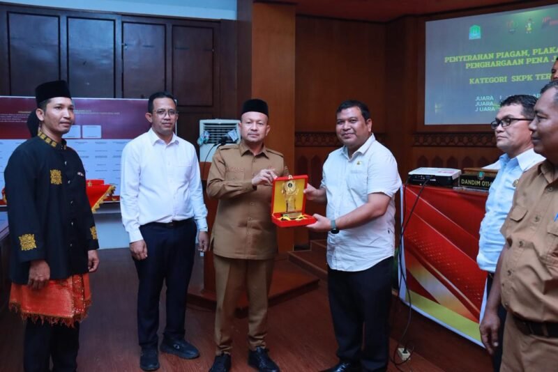Bupati Aceh Jaya menyerahkan penghargaan kepada SKPK terinovatif pada acara penganugerahan PENA JAYA 2025