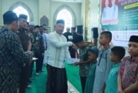 Bupati Aceh Jaya, Safwandi, saat menyerahkan santunan kepada anak yatim di Masjid Agung Baitul Izzah, Calang